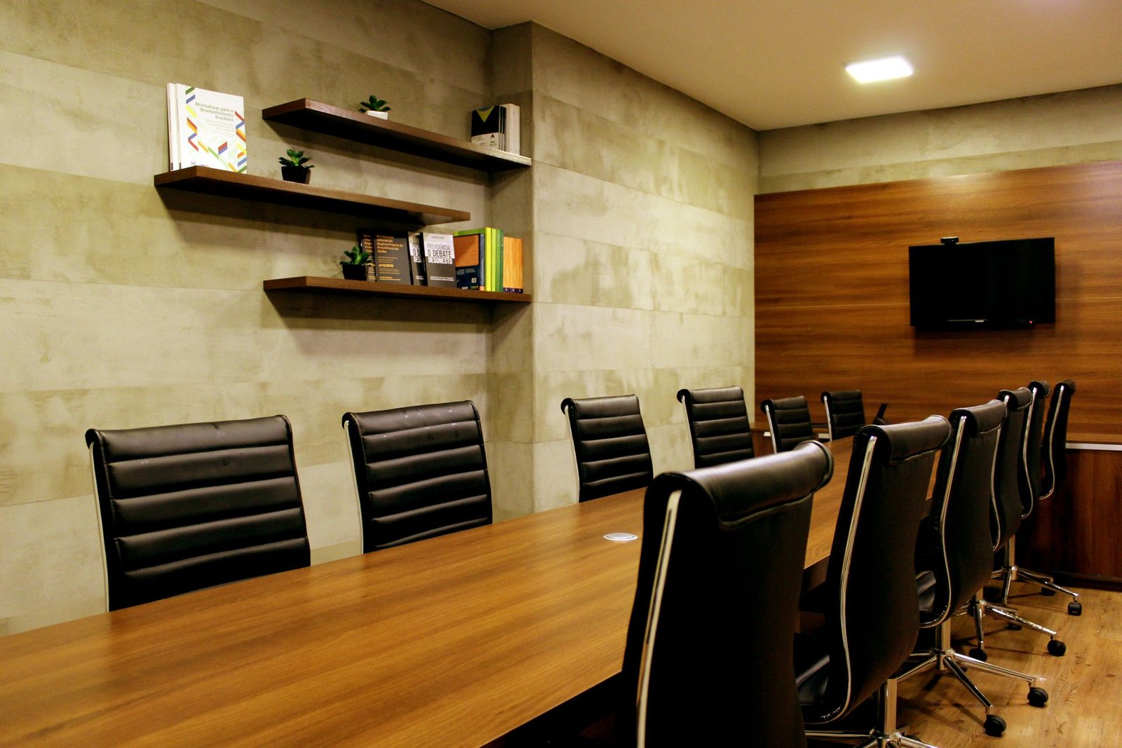Boardroom furnished with a walnut meeting table and black leather executive chairs